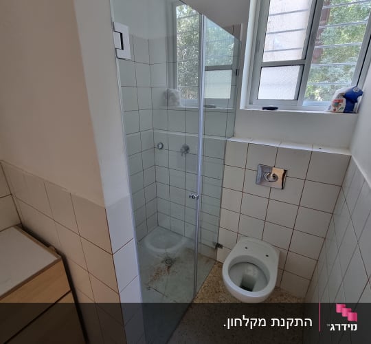 מקלחון זכוכית עם אריחים לבנים וברזי מים